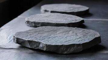 Three Gray Stone Coasters on a Slate Surface photo