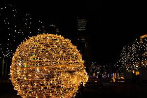 Closeup of intertwined golden string lights. Abstract view of crisscrossing glowing yellow LED garland with small bright bulbs, radiating light against a dark background. Berlin, Germany. Copy space photo