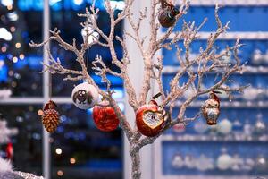 Berlin, Germany, January 5th, 2024. Festive display with unique Christmas ornaments at Berlin seasonal market. Delicately handcrafted owl and heart figures on sparkling glittering tree branch photo