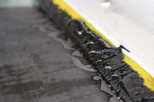 A black and yellow strip of tape on the floor photo