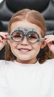 A doctor diagnosing a little girl vision and selecting lenses using a modern medical device. Perfect for illustrating diagnostics and vision correction video