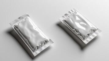 Two sleek silver packets rest on a clean, light surface, reflecting subtle glimmers photo