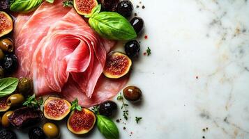 Sliced cured meats elegantly arranged with figs and olives, garnished with basil leaves photo