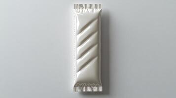 A sleek white chocolate bar rests elegantly on a plain surface, inviting indulgence photo