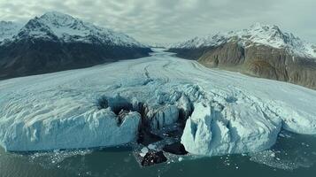 A large glacier dramatically breaks apart, creating splashes in the serene water below photo