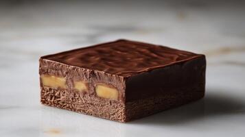 A rich chocolate square reveals a smooth caramel layer, enticing dessert enthusiasts photo