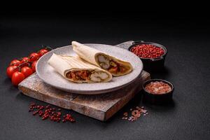 Roll with pita, meat, tomatoes, cheese, sauce, salt and spices photo