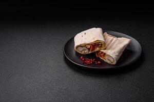 Roll with pita, meat, tomatoes, cheese, sauce, salt and spices photo