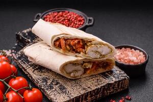 Roll with pita, meat, tomatoes, cheese, sauce, salt and spices photo