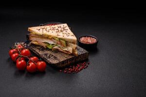 Sandwich with toast bread, meat, tomatoes, cheese, sauce, salt and spices photo