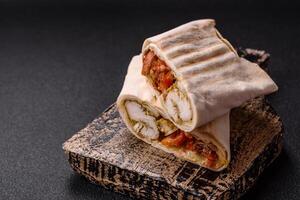 Roll with pita, meat, tomatoes, cheese, sauce, salt and spices photo