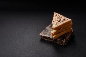 Sandwich with toast bread, meat, tomatoes, cheese, sauce, salt and spices photo
