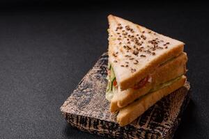 Sandwich with toast bread, meat, tomatoes, cheese, sauce, salt and spices photo