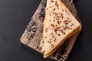Sandwich with toast bread, meat, tomatoes, cheese, sauce, salt and spices photo