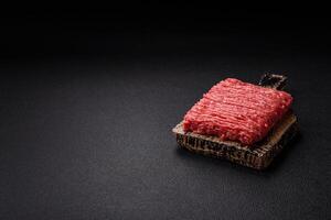 Fresh raw ground beef with salt, spices and herbs photo