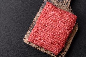 Fresh raw ground beef with salt, spices and herbs photo