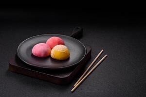 Delicious colorful asian mochi sweets with rice dough shell and fruit filling photo