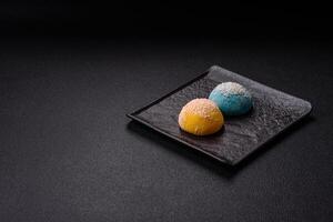 Delicious colorful asian mochi sweets with rice dough shell and fruit filling photo