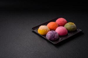 Delicious colorful asian mochi sweets with rice dough shell and fruit filling photo