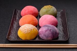 Delicious colorful asian mochi sweets with rice dough shell and fruit filling photo