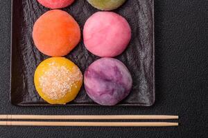 Delicious colorful asian mochi sweets with rice dough shell and fruit filling photo