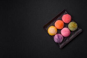 Delicious colorful asian mochi sweets with rice dough shell and fruit filling photo