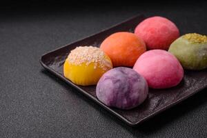 Delicious colorful asian mochi sweets with rice dough shell and fruit filling photo