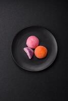 Delicious colorful asian mochi sweets with rice dough shell and fruit filling photo