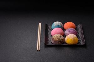 Delicious colorful asian mochi sweets with rice dough shell and fruit filling photo