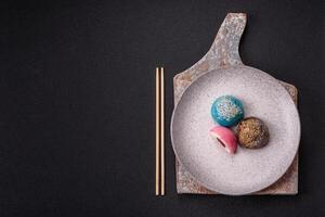 Delicious colorful asian mochi sweets with rice dough shell and fruit filling photo