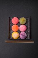 Delicious colorful asian mochi sweets with rice dough shell and fruit filling photo