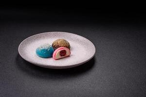 Delicious colorful asian mochi sweets with rice dough shell and fruit filling photo