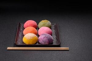 Delicious colorful asian mochi sweets with rice dough shell and fruit filling photo
