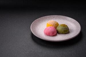 Delicious colorful asian mochi sweets with rice dough shell and fruit filling photo