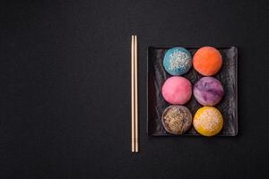 Delicious colorful asian mochi sweets with rice dough shell and fruit filling photo