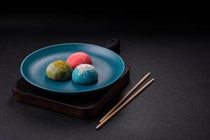 Delicious colorful asian mochi sweets with rice dough shell and fruit filling photo