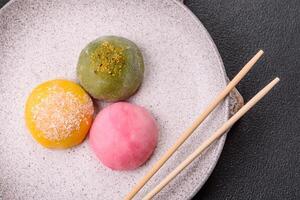Delicious colorful asian mochi sweets with rice dough shell and fruit filling photo