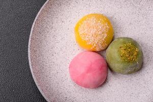 Delicious colorful asian mochi sweets with rice dough shell and fruit filling photo