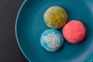 Delicious colorful asian mochi sweets with rice dough shell and fruit filling photo