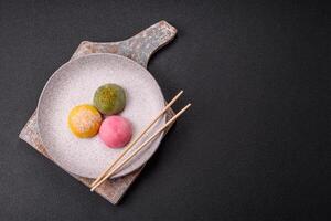 Delicious colorful asian mochi sweets with rice dough shell and fruit filling photo