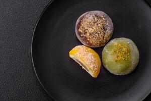 Delicious colorful asian mochi sweets with rice dough shell and fruit filling photo