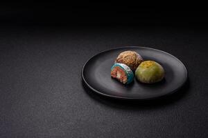 Delicious colorful asian mochi sweets with rice dough shell and fruit filling photo