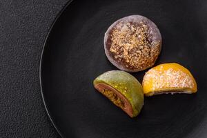 Delicious colorful asian mochi sweets with rice dough shell and fruit filling photo