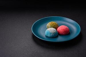 Delicious colorful asian mochi sweets with rice dough shell and fruit filling photo