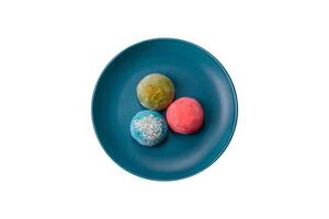 Delicious colorful asian mochi sweets with rice dough shell and fruit filling photo
