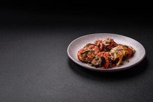 Rings of eggplant, tomato and zucchini with pieces of chicken and garlic photo