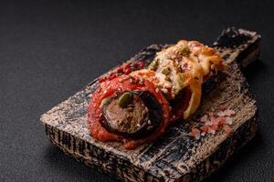Rings of eggplant, tomato and zucchini with pieces of chicken and garlic photo