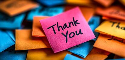 Thank you notes in vivid colors scattered. A vibrant collection of sticky notes in various colors displaying gratitude messages, creating an uplifting atmosphere of appreciation. photo