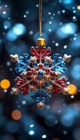 A snowflake ornament with blue, red, and gold beads hanging from a chain. The snowflake is suspended in the air, surrounded by a blurry background. Concept of warmth and holiday cheer photo