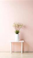 A white table with a vase of flowers in front of a pink wall photo